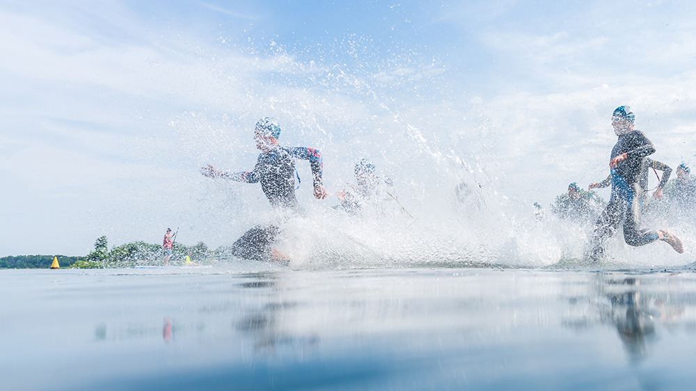 Triathletes running into open water