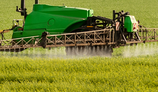 Tractor in a field with wind turbines in the background