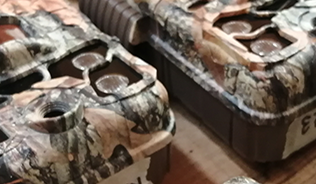 A photo of camouflage trail cameras laid out on a worktop